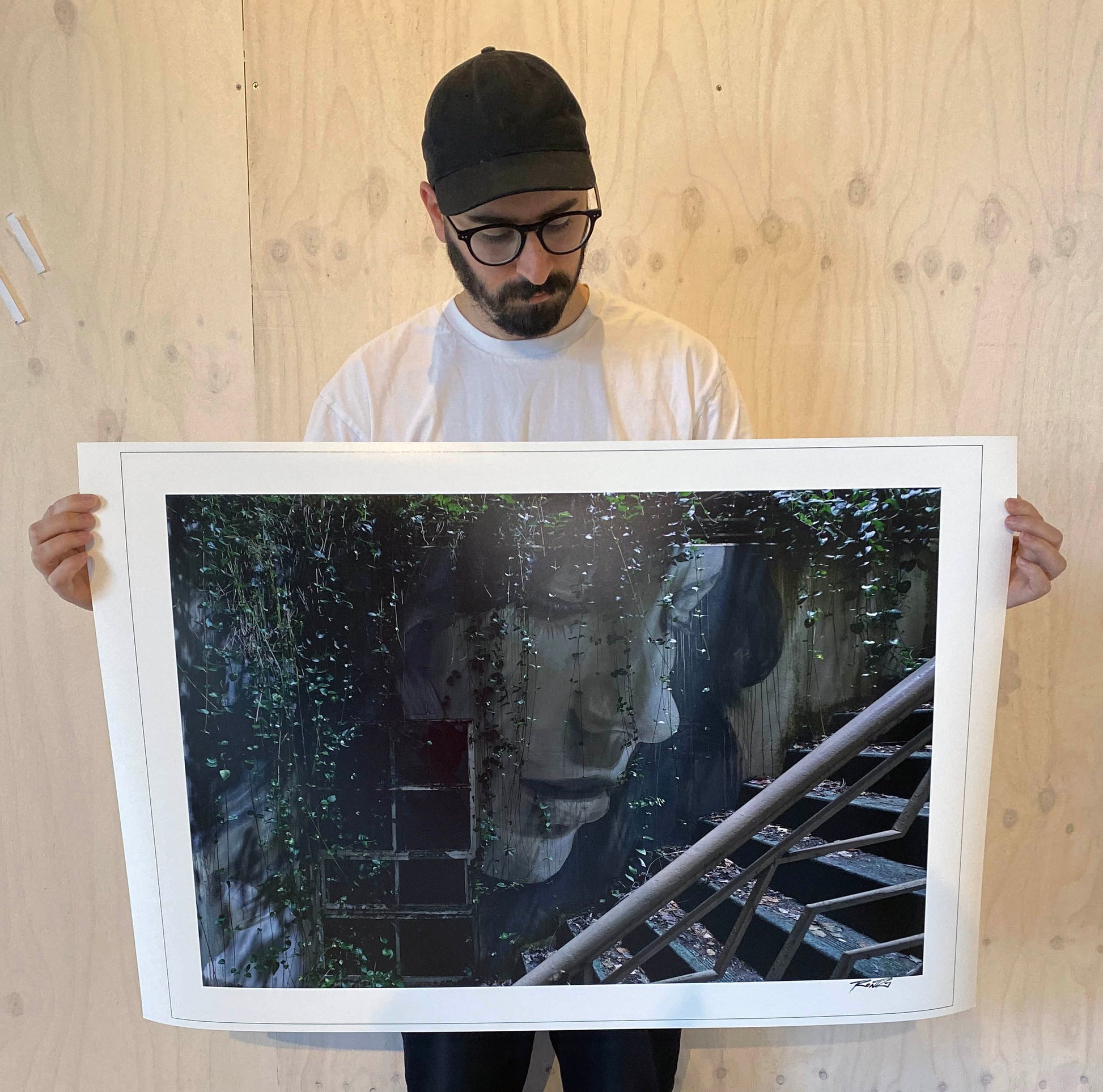 Image of the Australian Artist Rone holding photographic print from Empire Exhibition. 